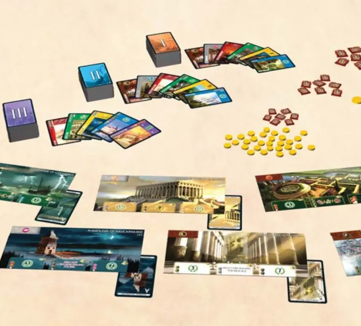 Componentes de 7 Wonders: mazos de las tres eras, monedas, fichas de conflicto y tableros de maravilla.
