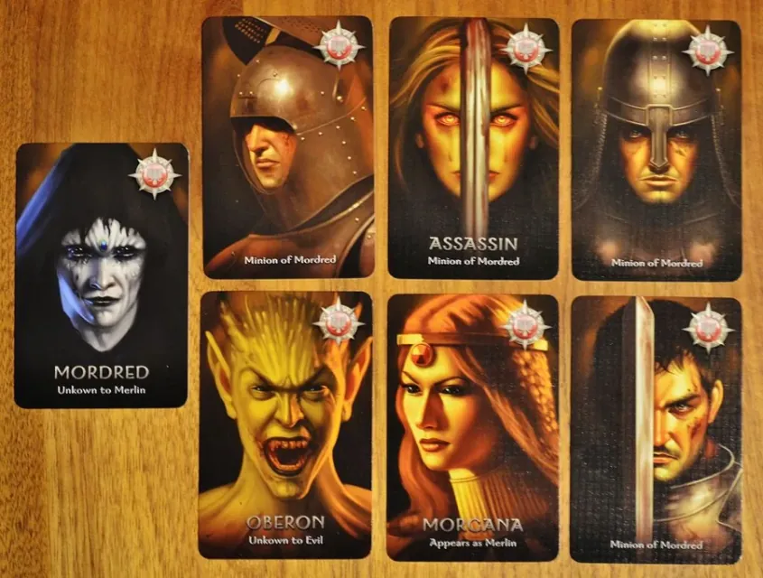 Evil character cards: Mordred, the Assassin, Oberon, Morgana and two Minions of Mordred on a wooden table.