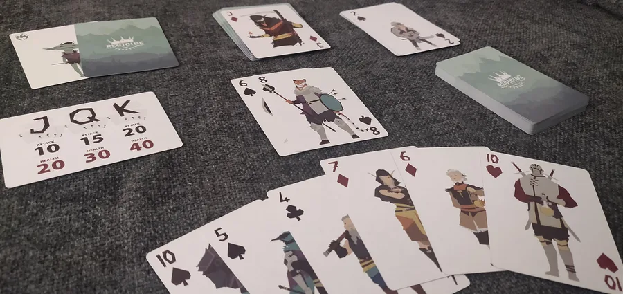A solo game of Regicide in progress with cards in hand, the tavern deck, the enemy reference card and the castle deck.